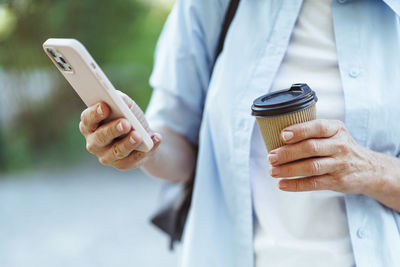 Midsection of man using mobile phone