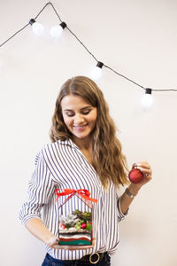 Portrait of smiling young woman holding food