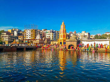 Group of people in front of buildings against blue sky