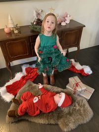 High angle portrait of girl with christmas presents and doll standing at home