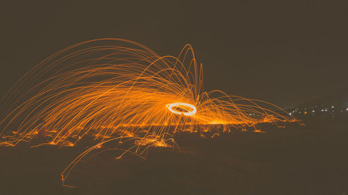 Firework display against sky at night