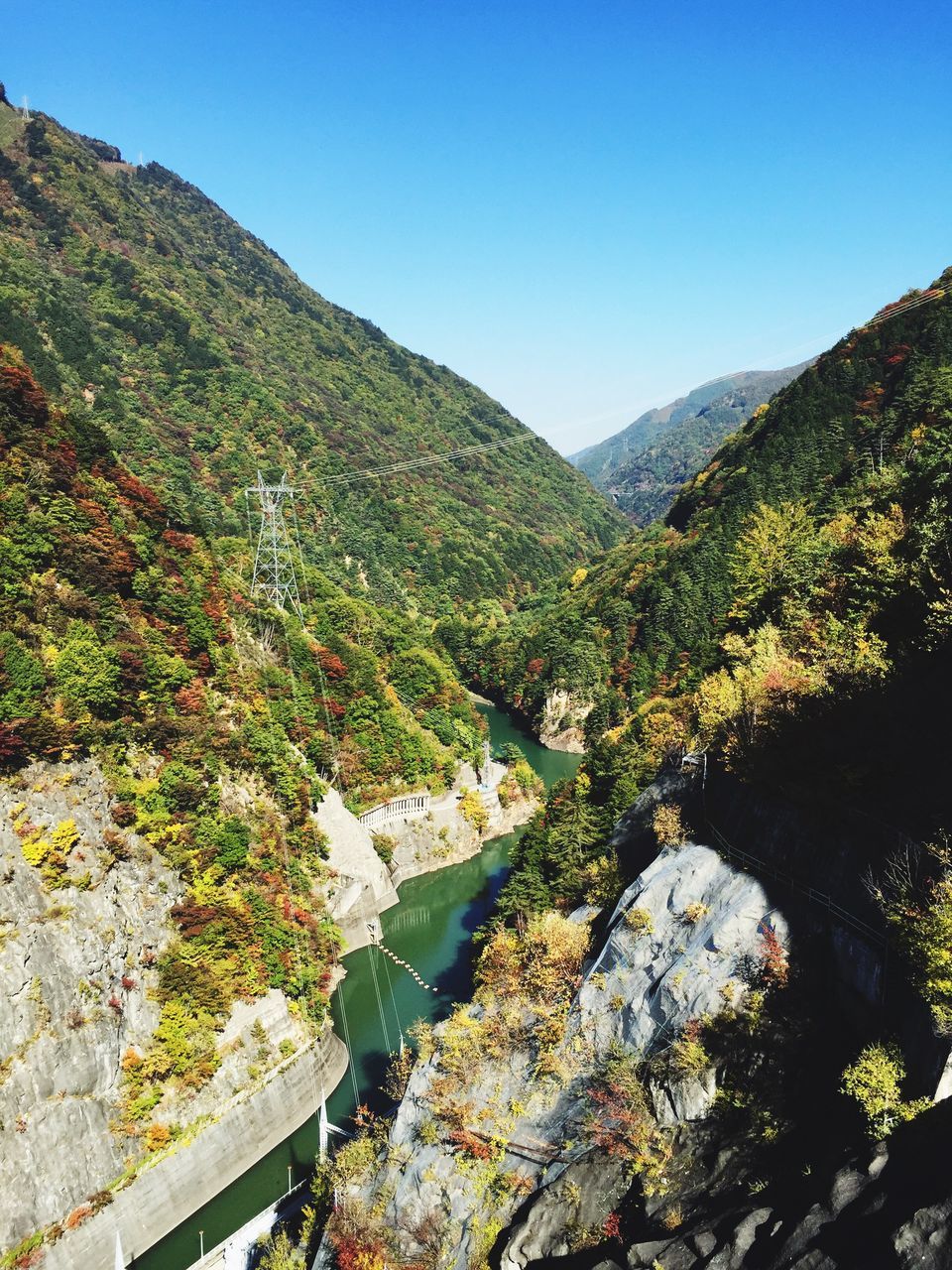 mountain, clear sky, blue, tranquil scene, tranquility, beauty in nature, scenics, mountain range, copy space, nature, tree, water, idyllic, landscape, non-urban scene, sunlight, lake, day, rock - object, outdoors