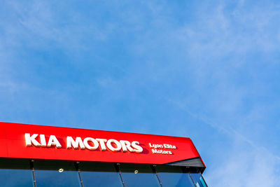 Low angle view of information sign against blue sky