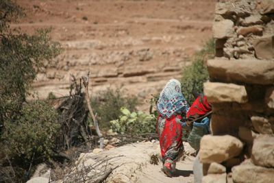 Rear view of woman working on rock