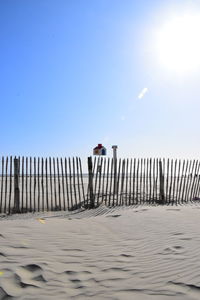 Wooden post on beach against clear sky