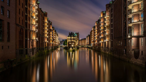 Canal passing through city at night