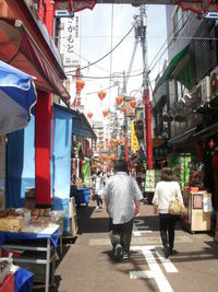 Rear view of people walking on street market