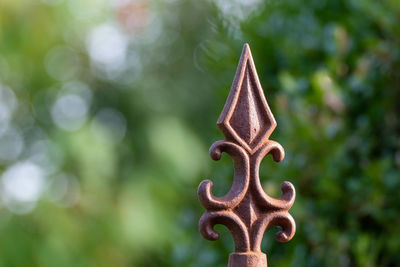 Close-up of rusty metal fence against trees