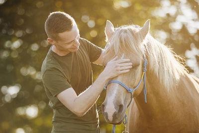 Man is embracing of therapy horse. themes hippotherapy and friendship between people and animals.