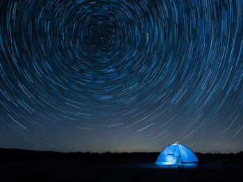 Scenic view of illuminated tent against sky at night