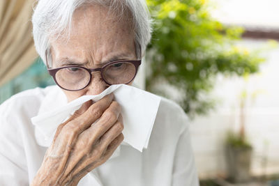 Senior woman blowing nose