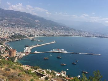 High angle view of city by sea against sky