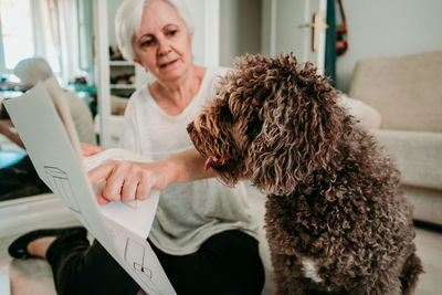 Woman with dog working on wood at home