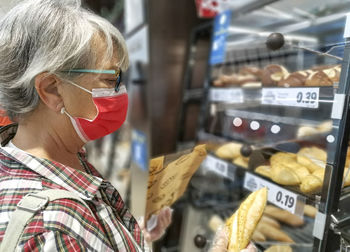 Close-up of senior woman wearing mask shopping at store