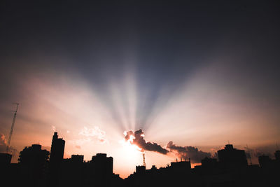 Silhouette buildings against sky during sunset