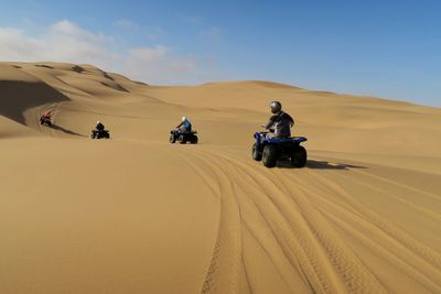 People riding off-road vehicles in the desert