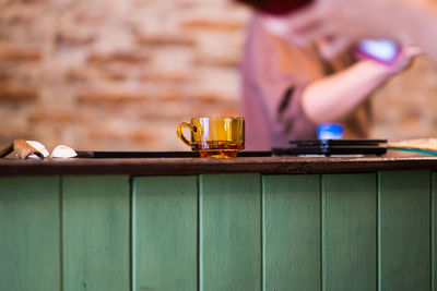 Midsection of man holding drink on table