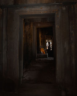 Rear view of woman walking in corridor of historic building