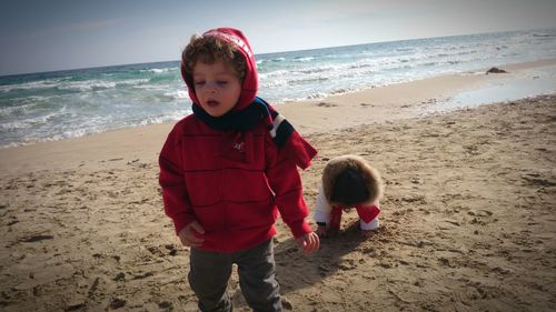 Boy standing on beach against sea