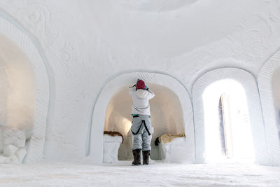 Woman carving snow in igloo