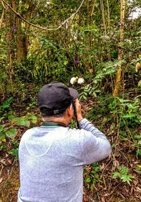 Rear view of a man standing in forest