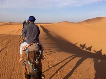 Rear view of man riding in desert