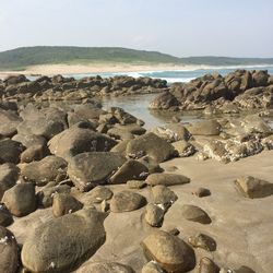 Rocks on beach against clear sky