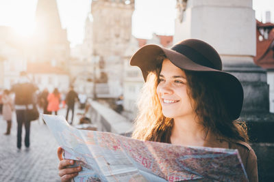 Portrait of smiling woman holding umbrella in city