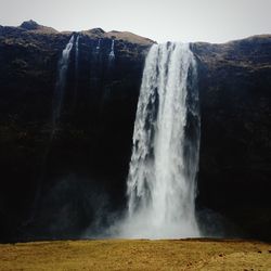 Scenic view of waterfall against sky