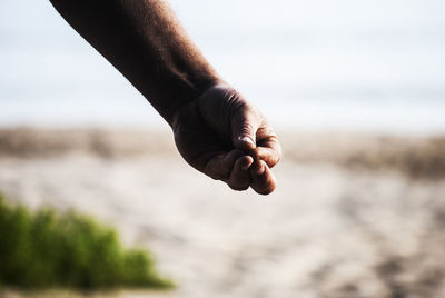 Cropped hand of person gesturing against sky