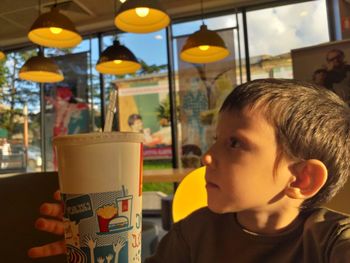 Close-up portrait of boy drinking glass in restaurant