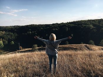 Full length of woman standing on field against sky