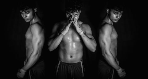 Young man standing against black background