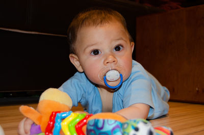 Portrait of cute baby lying on floor at home