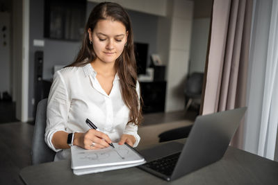 Portrait of young businesswoman working at home