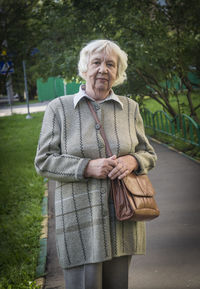 Portrait of senior woman standing on footpath