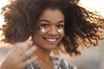 Portrait of teenage girl with glitter on face outdoors