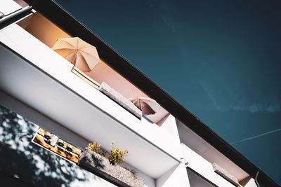 Low angle view of building by swimming pool against sky