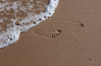 High angle view of footprints on sand at beach