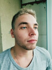 Close-up portrait of young man against wall