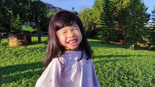 Portrait of smiling girl standing by plants