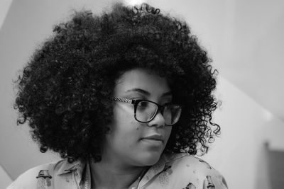 Close-up of woman with curly hair looking away at home