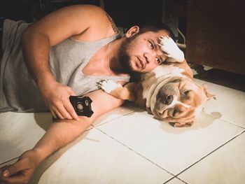 Man with dog lying down on floor at home