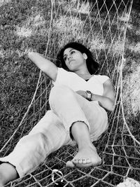 Woman relaxing on hammock over field