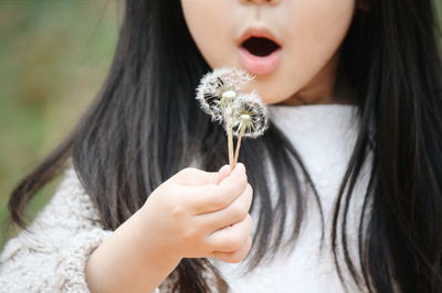 Close-up of kid holding dandelion flower
