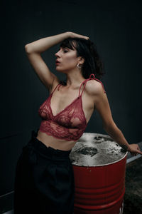 Midsection of woman standing against red wall