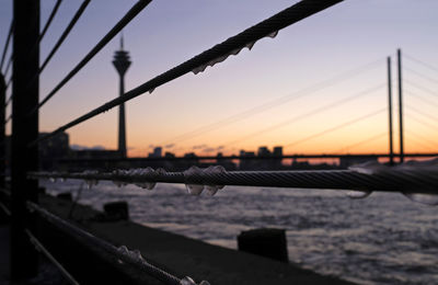 Bridge over sea against sky during sunset