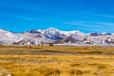 Scenic view of snowcapped mountains against blue sky