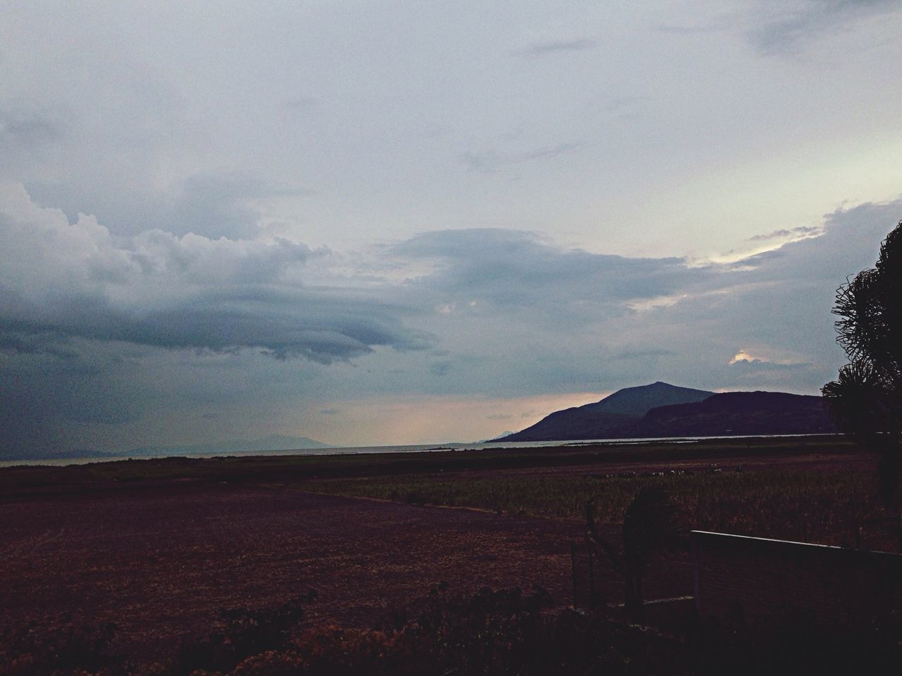 sky, landscape, cloud - sky, tranquil scene, tranquility, scenics, house, built structure, building exterior, field, beauty in nature, architecture, nature, cloudy, mountain, cloud, rural scene, outdoors, non-urban scene, horizon over land