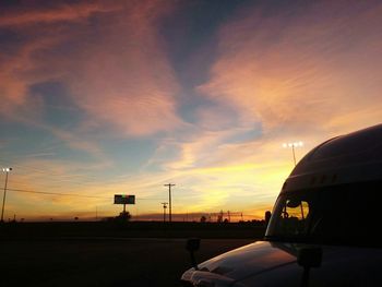 Silhouette of train against sky at sunset